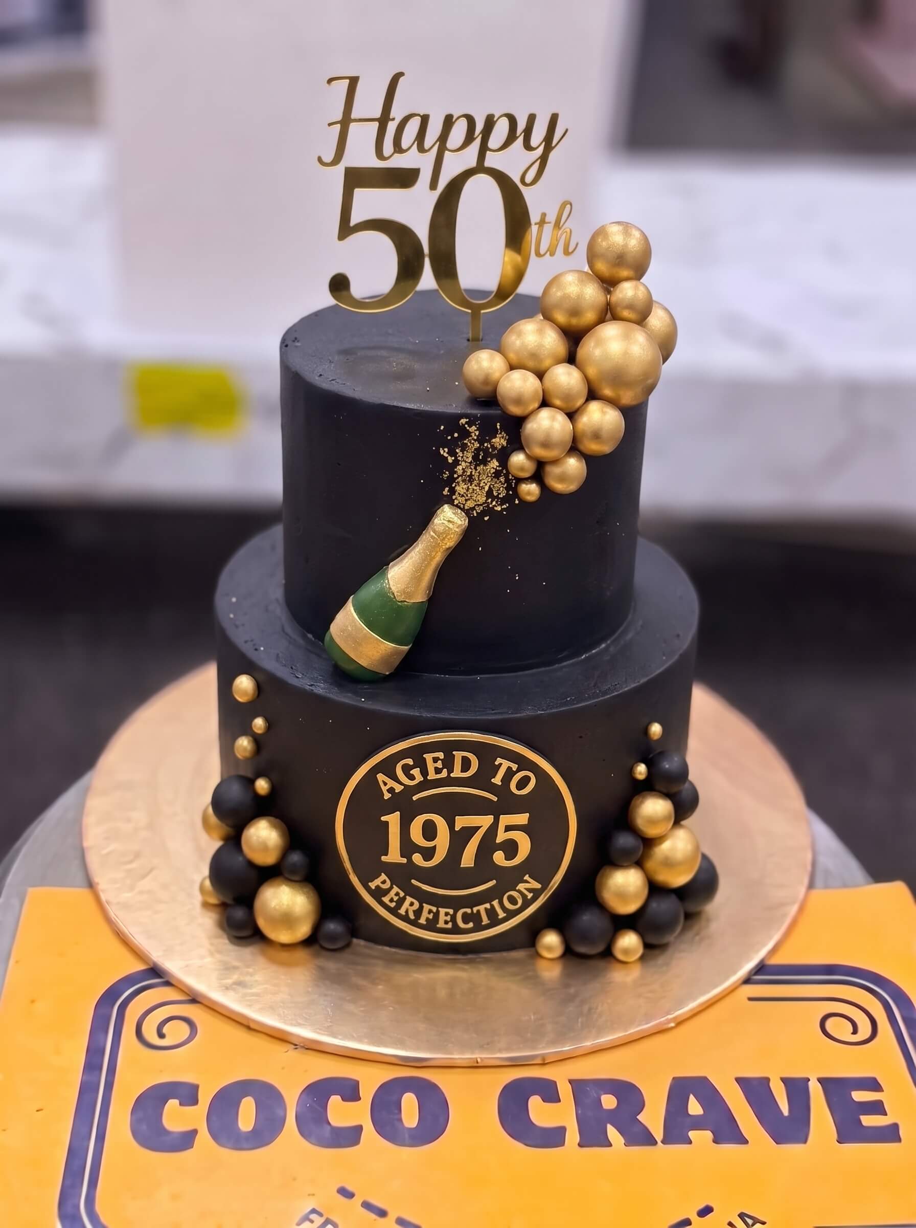 Black and Gold Champagne Birthday Cake in Lahore by CocoCrave.pk Black and Gold Champagne Birthday Cake in Lahore