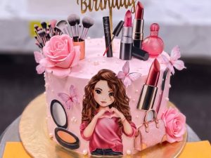 Barbie Fashion Girl Cake in Lahore — A pink cake with a printed fashion-girl portrait on the front, fresh-look sugar roses and a crowded top of lip