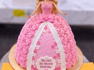 Pink Barbie Doll Cake in Lahore — The classic Barbie doll cake: a real doll set into a full pink buttercream gown piped rosette by rosette, with