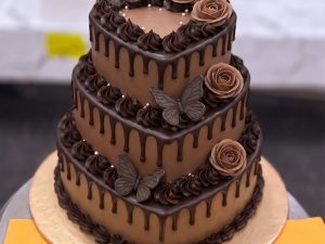 Three Tier Chocolate Rose Cake in Lahore — A three tier chocolate cake with piped chocolate roses, butterflies and a drip on every tier — an elegant larg