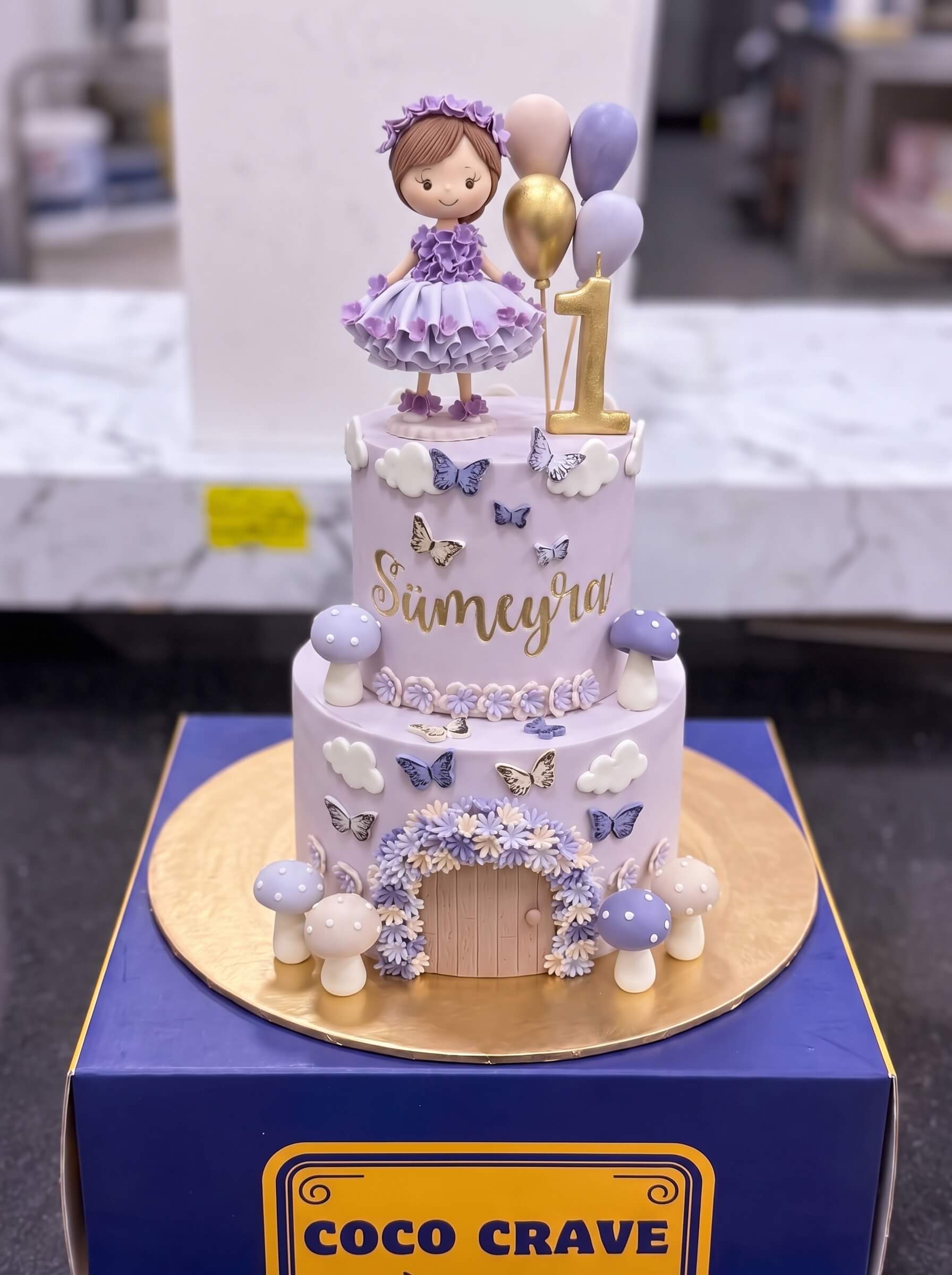 Pastel Doll Butterfly Cake in Lahore — CocoCrave.pk Pastel Doll Butterfly Cake in Lahore by CocoCrave.pk — three tier doll and butterflies cake in lilac, pink and cream