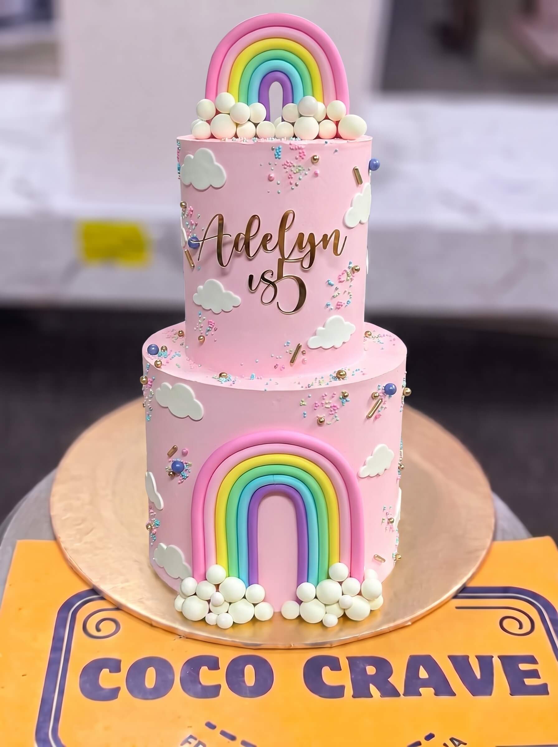 Pink Rainbow Birthday Cake in Lahore — CocoCrave.pk Pink Rainbow Birthday Cake in Lahore by CocoCrave.pk — two tier pastel rainbow cake in pink and rainbow