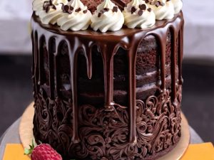 Chocolate Drip Cake with Cream Rosettes in Lahore — A dark chocolate drip cake with white cream rosettes, chocolate chips and a fresh raspberry finish — a balance