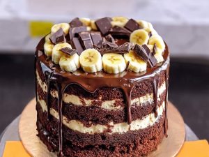 Ferrero Rocher Chocolate Drip Cake in Lahore — A tall chocolate drip cake loaded with Ferrero Rocher, chocolate bar shards and hazelnut cream layers — the Fe