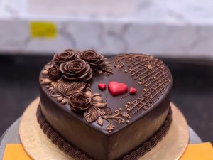 Chocolate Heart Cake in Lahore — A heart-shaped chocolate cake finished in glossy ganache with hand-piped chocolate roses and red hearts — the