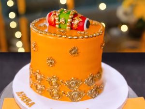 Orange Gold Beaded Mayoun Cake in Lahore — An orange mayoun cake covered in hand-placed gold beading — hundreds of individual pearls set one at a time.