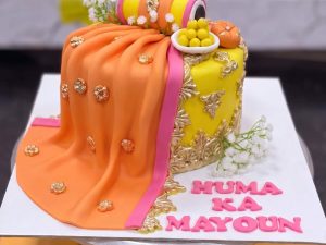 Orange Dupatta Drape Mayoun Cake in Lahore — A fondant dupatta in deep orange draped across the cake and finished with gota-style trim — the mayoun cake th