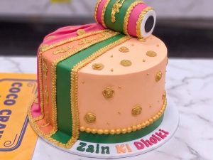 Peach & Green Dholki Mayoun Cake in Lahore — A peach and green mayoun cake topped with a sugar dholki — the drum that starts every Pakistani wedding, made