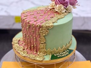 Pastel Green & Pink Floral Mehndi Cake in Lahore — A pastel green mehndi cake scattered with piped pink blossoms — soft, garden-toned, and made for a daytime meh