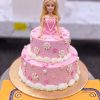 Barbie Bow Doll Cake in Lahore 2 Barbie Bow Doll Cake in Lahore — A two tier pink doll cake with a Barbie in a bow headband, white blossoms across both tiers and neat shell pip